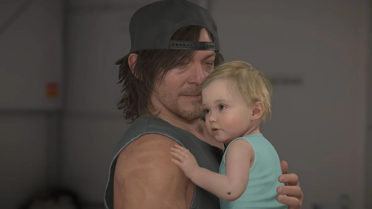 Death Stranding 2 Geburtstag DOOMS: Sam blickt auf Lou, während er sie an seine Brust hält.