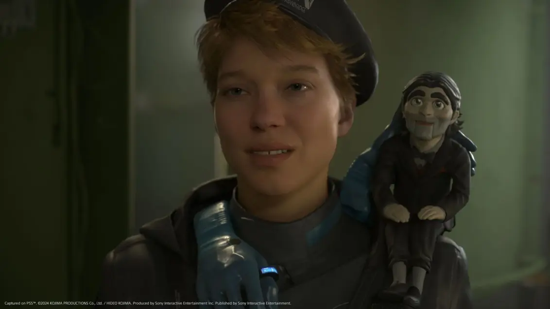 Eine lebende Puppe sitzt auf Fragiles Schulter in einem Death Stranding 2 PS5 Screenshot