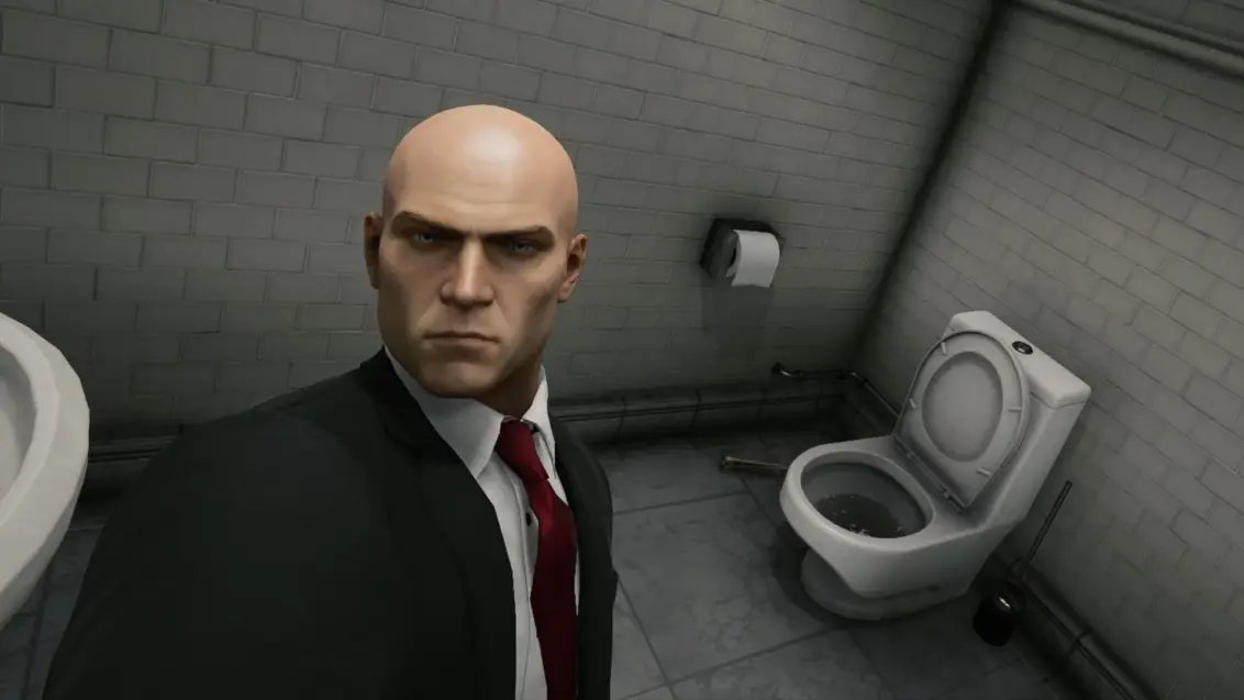Agent 47 macht ein Selfie mit einer Toilette in Hitman: World of Assassination.