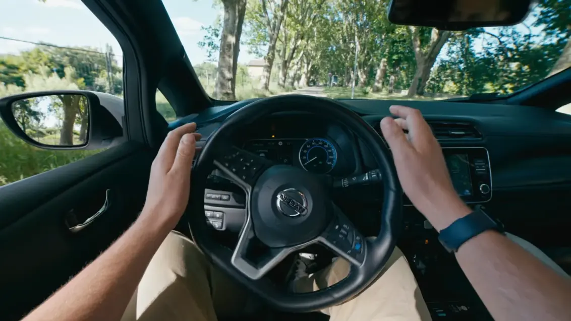 Blick vom Fahrersitz auf ein Lenkrad, das sich ohne direkte Kontrolle des Fahrers dreht.