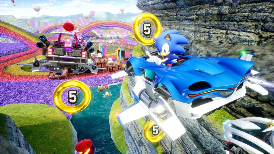 Sonic Racing: CrossWorlds Screenshot von Sonic, der mit dem Finger wackelt und hinter sich schaut, während er auf der Luftstrecke in einem blauen Auto mit nummerierten Ringen um ihn herum schwebt