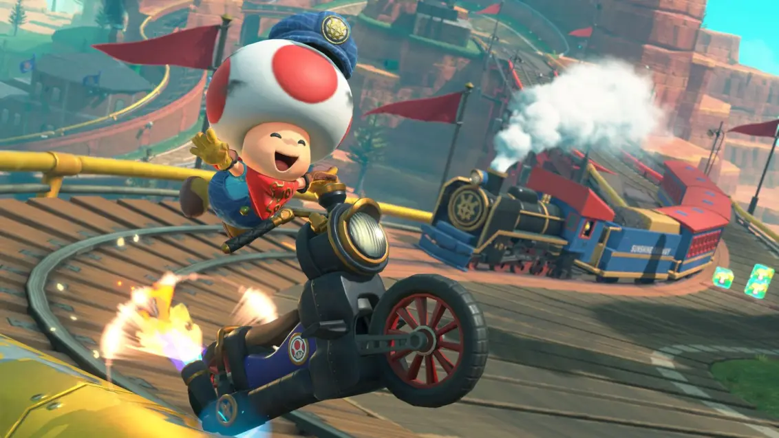 Mario Kart World Screenshot zeigt Toad, der auf einem Motorrad fährt, mit einem Zug in der Ferne.