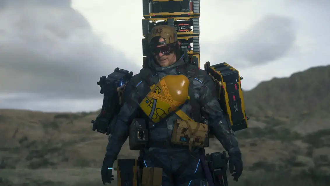 Death Stranding 2 Statistiken: Sam trägt viel Fracht und geht auf die Kamera zu, während er Sonnenbrillen trägt.