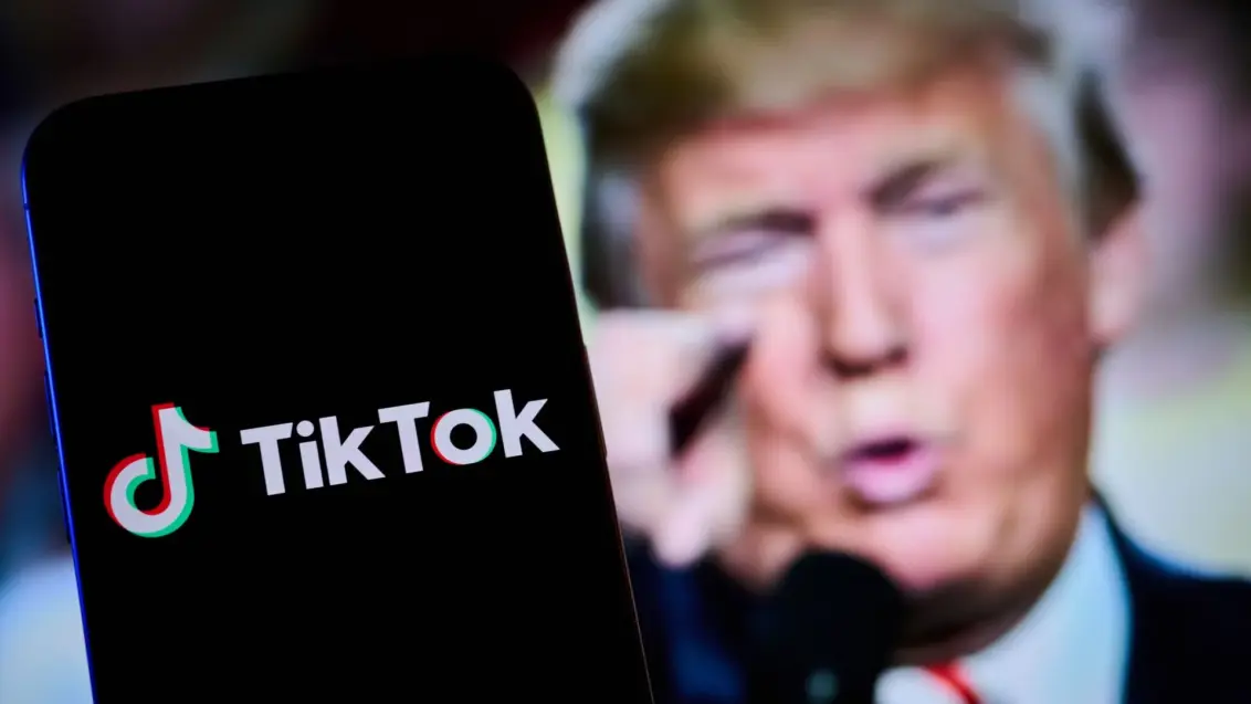 Die TikTok-App mit Donald Trump im Hintergrund.